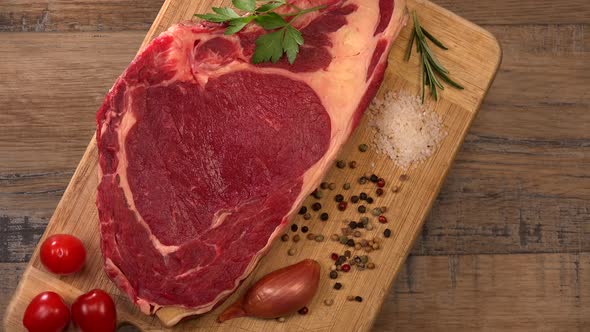 Raw T Bone steak on wooden board prepared to Grill, Entrecote, on turntable, France