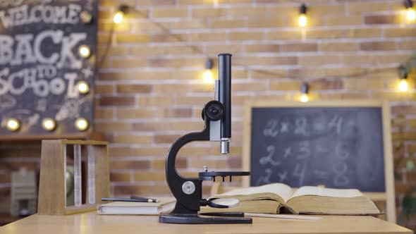 Empty Classroom with Chalkboard Desk Microscope and Textbook