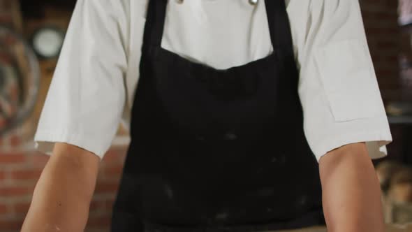 Animation of happy asian female baker rolling sourdough for bread