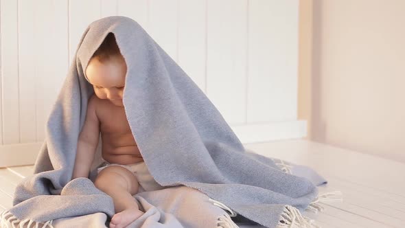 Baby Plays Peekaboo Hiding Under a Blanket.