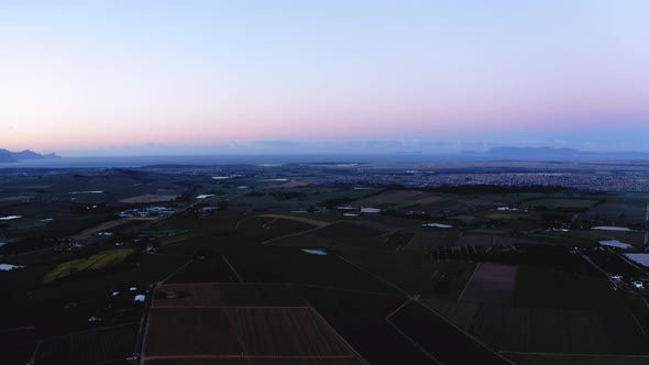 Aerial drone, dusk sunrise over farm land, ponds, dams and vineyards, light blue, pink and purple sk