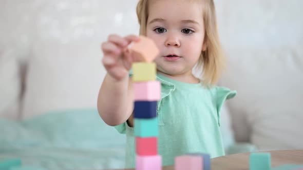Adorable Little Girl Playing with Colorful Wooden Cubes