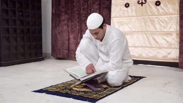 Indian man reading Quran at home