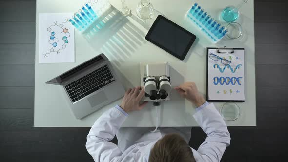 Scientist Opening Computer and Setting Up Microscope in Laboratory, Top View