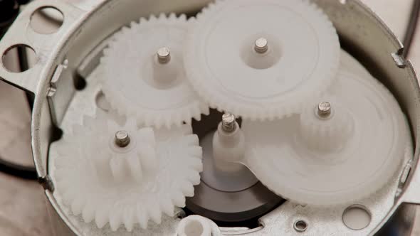 Five Plastic Gears Rotate in Mutual Mesh Inside a Small Reduction Gear