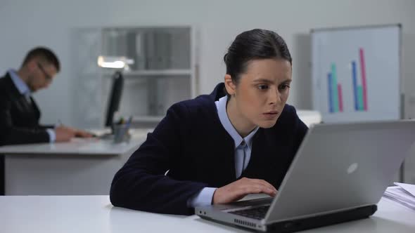 Female Manager Attentively Reading Documents on Laptop, Searching for Mistake