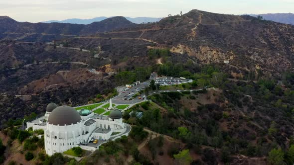 AERIAL Over Griffith Observatory with Hollywood Hills in Daylight Los Angeles California Cloudy