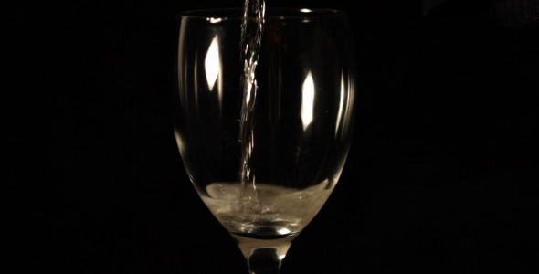 Pouring Champagne Into Glass On Black