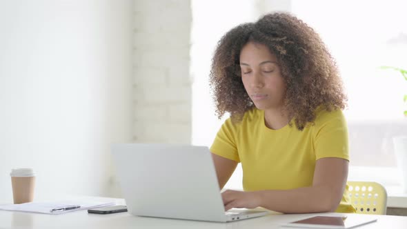 African Woman with Laptop Smiling in Camera