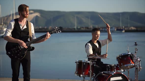 Musicians Playing Drums and Guitar During Outdoor Band Performance