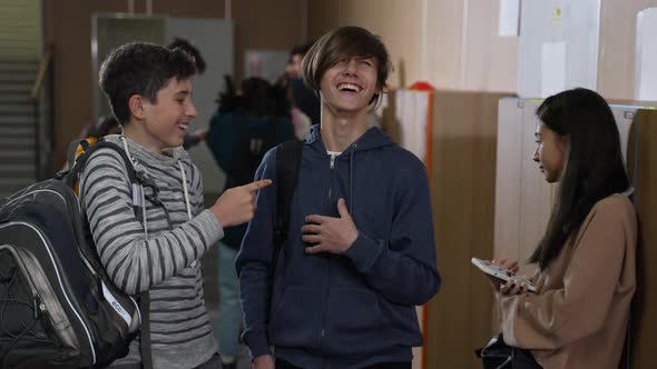 Two Schoolboys Mocking Asian Girl at School