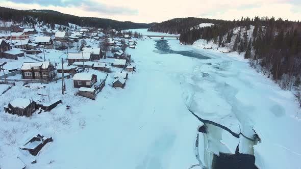 Snow, village and river under the ice