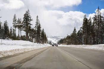 mountains close to lake Tahoe on a sunny winter day; the road has been cleared on snow, California