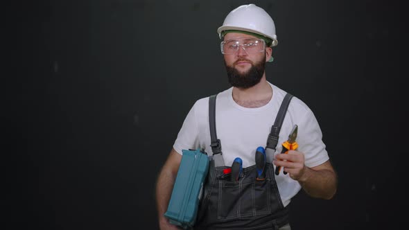 Skilled Cheerful Workman in Hard Hat and Overall with Tools