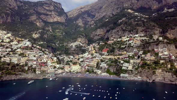 Positano in the Amalfi coast of Italy with boats anchored nearby, Aerial dolly out reveal shot