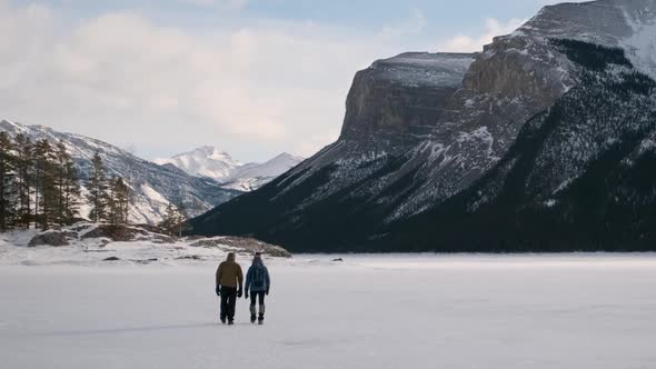 Young Hiking Couple Enjoy a Breathtaking Winter Hike in Snowy Mountains of Banff National Park at La