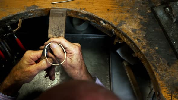 Goldsmith manufacturing jewellery in workshop