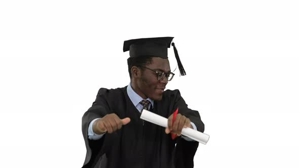 Excited African American Male Student in Graduation Robe Dancing Happily with His Diploma on White