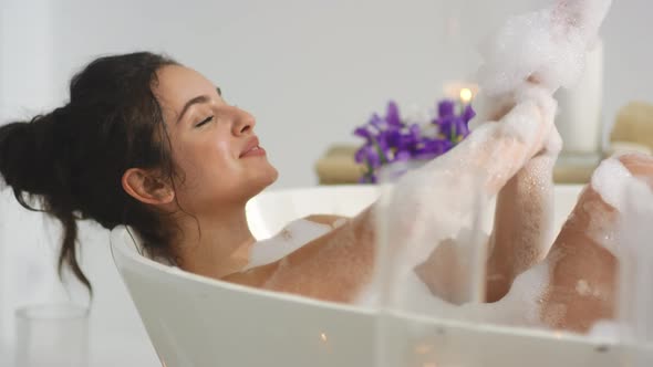 Closeup Relaxed Woman Washing Hands in Foam Bath. Hot Girl Resting in Bathtub.