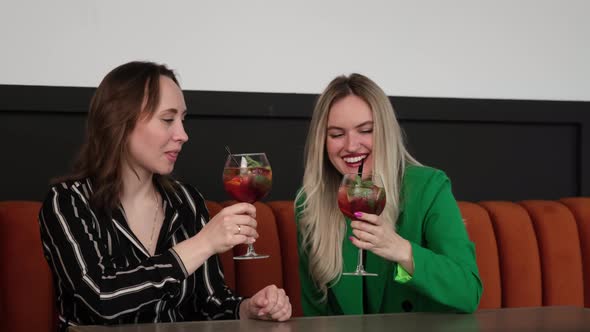 Girlfriends Raise Glasses with a Cocktail