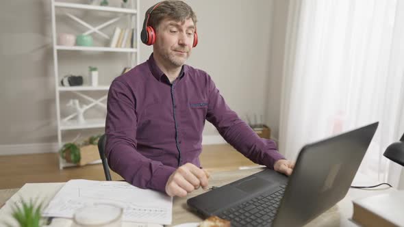 Middle Aged Caucasian Man Making Victory Gesture and Dancing After Waving Goodbye in Video Chat and