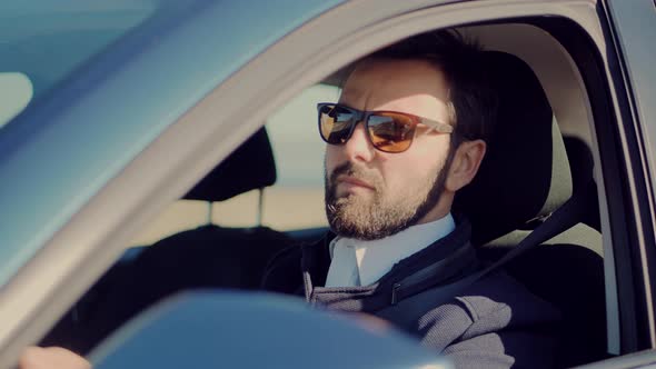 Male Driver Turning Steering Wheel In Car. Luxury SUV Driving. Hand On Car Steering Wheels.