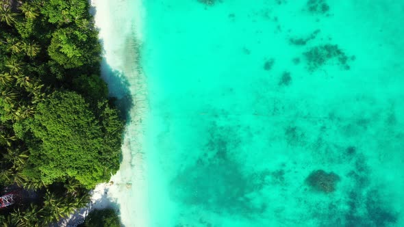 Beautiful above tourism shot of a white sandy paradise beach and blue ocean background in vibrant 4K