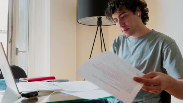 Young man working at laptop at home