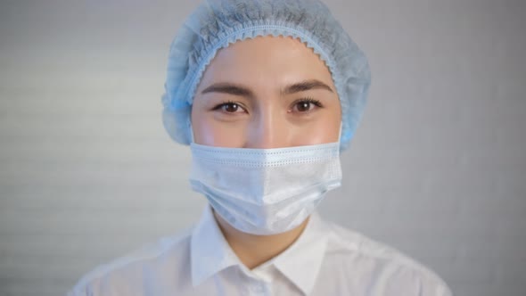 A female doctor smiles with her eyes under a protective medical mask