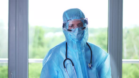 Portrait of Female Medical Worker, Doctor, in Special Protective Uniform, Mask, Glasses, with a alt