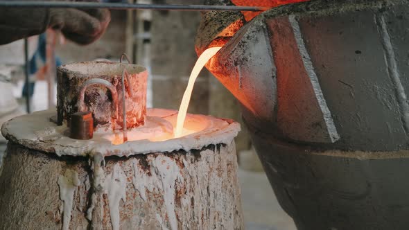 Orange and Yellow Hot Liquid Metal is Pouring to the Shape on Metals Production