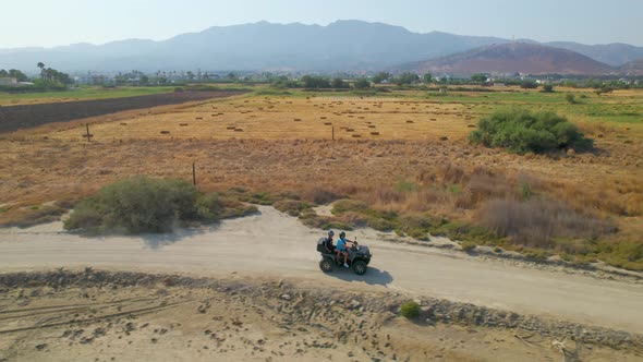 Side aerial view of ATV driving through Greek countryside