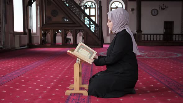 Women Praying On Quran Holder