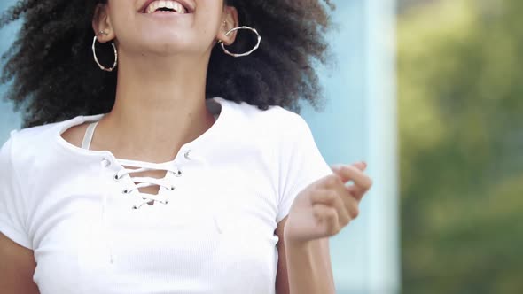 Cheerful Beautiful Cute Curly Afro American Young Woman Enjoys Jumping Holding Smartphone, Waving