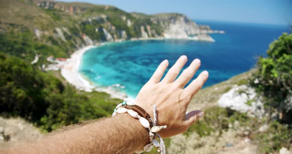 Man Hand Streached in the Air Towards Beautiful Beach