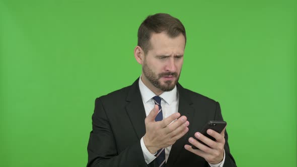 Businessman Get Disappointed While Using His Phone Against Chroma Key