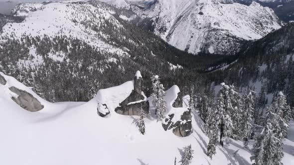 Breathtaking Aerial Reveal Of Sunny Forest Valley With Fresh Powder Snow On Mountain Range