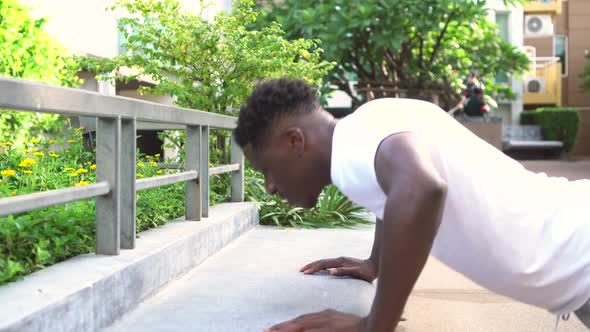 Young African American Man Doing Push Up in City Park