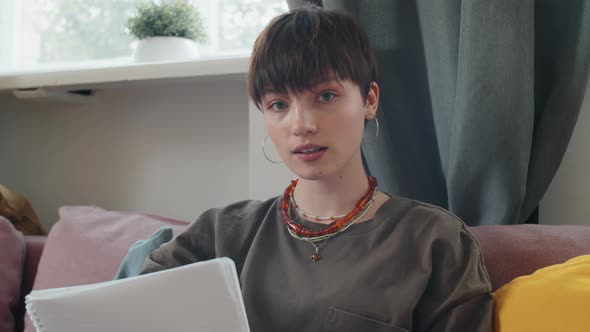 Young Girl Taking Notes during Online Lesson at Home