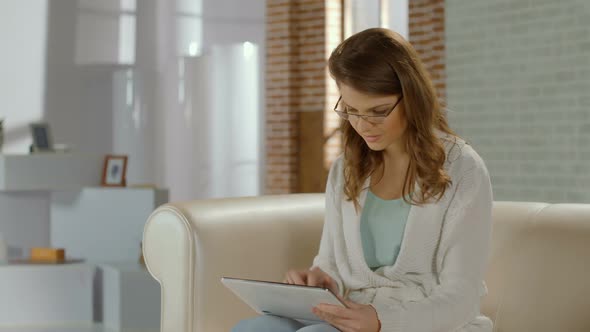 Girl in Glasses Communicating in Social Networks on Tablet PC