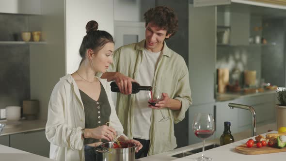 Man and Woman Drinking Wine While Cooking on Kitchen