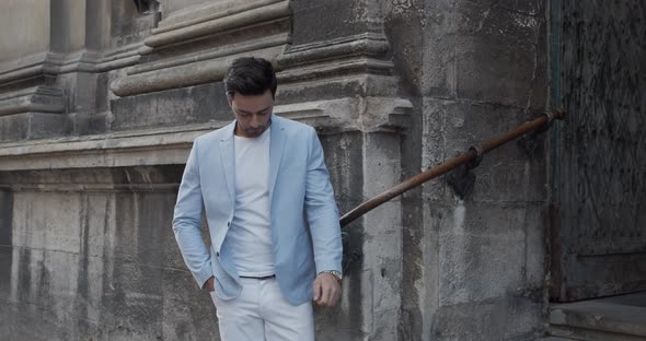 A Young Man Stands Near An Ancient Castle In A Festive Light Suit