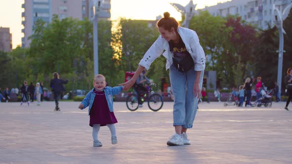 Baby Learning to Walk Toddler Taking First Steps with Mother Helping Infant Teaching Child at