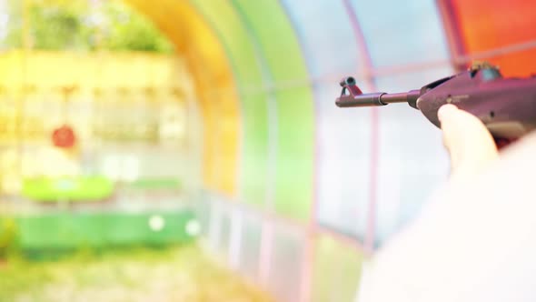 Close-up: Young Guy Shoots at Shooting Gallery From an Air Rifle