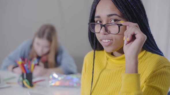 Close-up of Beautiful African American Woman Looking at Camera and Holding Eyeglasses