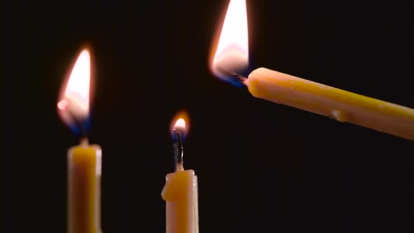 Person Sets a Candle in the Temple, Black Background