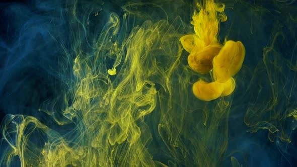 Beautiful yellow paint drops spreading in water