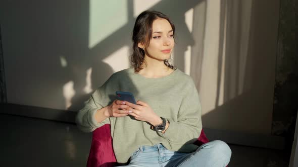 Portrait of a Beautiful Young Woman Sitting on Chair Enjoying Sunrise