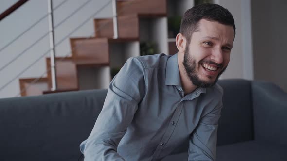 Cheerful Beard Man Is Sitting on Coach and Very Emotional Playing in Video Game.