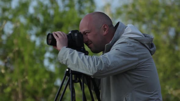 Man Male Cameraman Photographer with a Camera DSLR on a Tripod in the City Shoots Video Photo . Kyiv